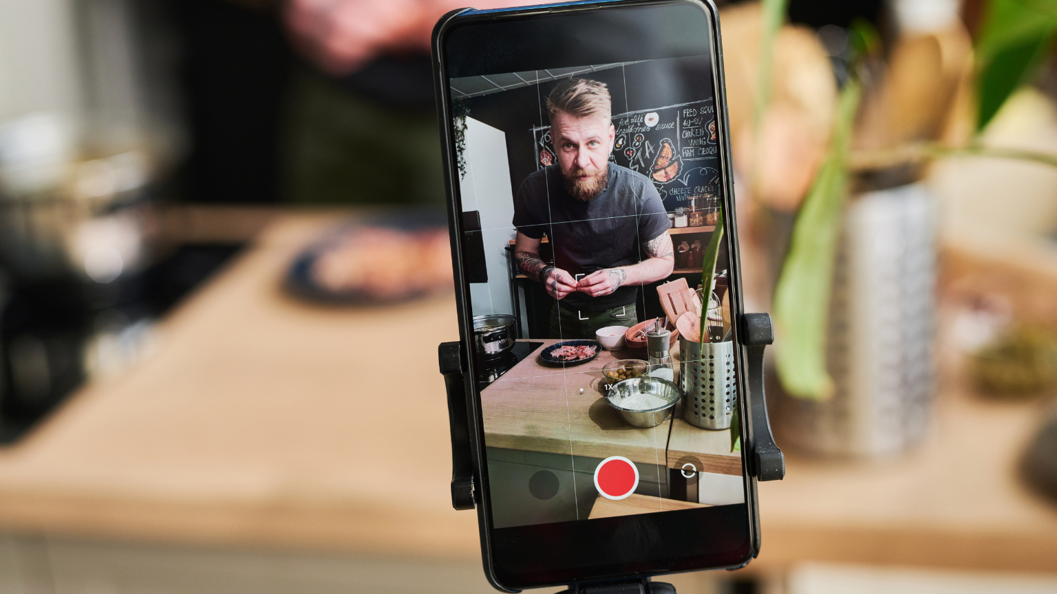 Téléphone filmant un restaurateur en cuisine pour créer du contenu local sur les réseaux sociaux